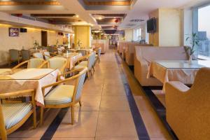 a restaurant with wooden tables and chairs and a cafeteria at Xinyuan Hot Spring Hotel in Haikou