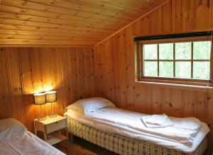 a bedroom with two beds in a wooden room at Vassbakken in Skjolden