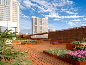 a balcony with flowers on a building with tall buildings at Golden Eagle Summit Hotel Downtown in Nanjing
