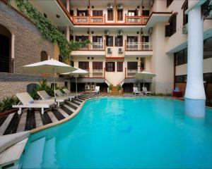 una piscina frente a un hotel con sillas y sombrillas en Hoi An Lantern Hotel, en Hoi An