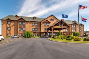 a large hotel with flags in a parking lot at Comfort Inn & Suites Macon in Macon