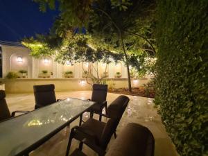 a table and chairs in a patio at night at Luxurious Ground Floor of a Villa in Elite Area in Amman