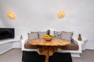 a room with a table with a bowl of fruit on it at Santorini Cave Suites Kontochori in Fira
