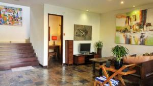 a living room with a couch and a television at Villa Saraswati in Ubud