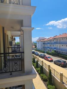 a balcony of a building with cars parked on a street at Domus Extra Apartments in Sveti Vlas