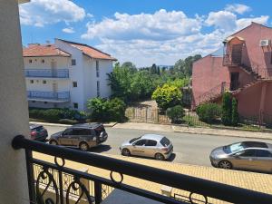 a balcony with cars parked on a street at Domus Extra Apartments in Sveti Vlas