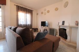 a living room with a couch and a fireplace at Casa Cor-de-Rosa in Vila Nova de Milfontes