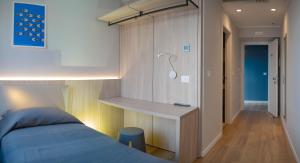 a bedroom with a bed and a desk with a shower at Hotel Tritone in Trieste