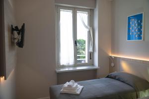 a bedroom with a bed and a window at Hotel Tritone in Trieste