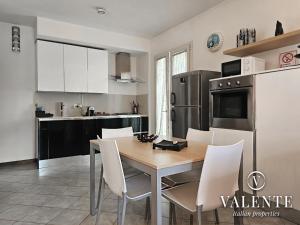 a kitchen with a wooden table and white chairs at Lamante apartment in Lucca in Lucca