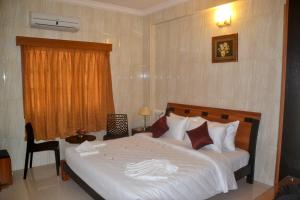 a bedroom with a large bed and a window at Peace Inn Chennai in Chennai