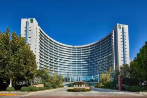a large white building with a fountain in front of it at Banyan Tree Tianjin Riverside in Tianjin