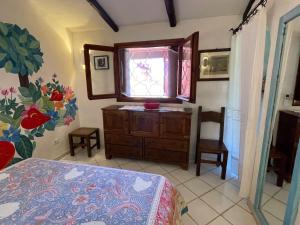 Cala BittaにあるVilla 200 mt from the beach - Baja Sardiniaのベッドルーム1室(ベッド1台、窓、ドレッサー付) +12枚の写真