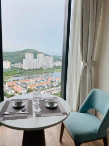 a table and chairs in a room with a window at Homstay A LA CARTE HẠ LONG 1PN in Ha Long