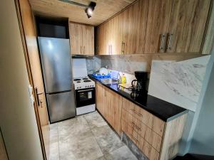 a kitchen with wooden cabinets and a stainless steel refrigerator at JTverga SEA VIEW HOMES A2 with Parking in Kalamata