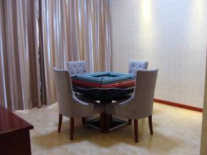 a ping pong table with two chairs in a room at Shanghai Jinghang Hotel in Shanghai