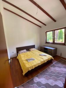 a bedroom with a bed and a large window at Vila Dina in Sarajevo