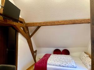 a bedroom with a bed with red shoes in it at Turmstube in Maring-Noviand