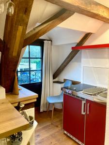 a kitchen with a red cabinet and a blue chair at Turmstube in Maring-Noviand
