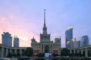 a building with a tower on top in a city at GreenTree Inn Shanghai South Railway Station Xujiahui Stadium Subway Station Shell Hotel in Shanghai