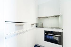 a white kitchen with white cabinets and an oven at La Suite Del Cavaliere in Amalfi