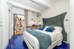 a bedroom with a large bed with blue pillows at La Suite Del Cavaliere in Amalfi