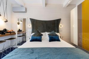 a bedroom with a large bed with blue pillows at La Suite Del Cavaliere in Amalfi