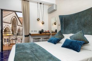 a bedroom with a large bed with blue pillows at La Suite Del Cavaliere in Amalfi
