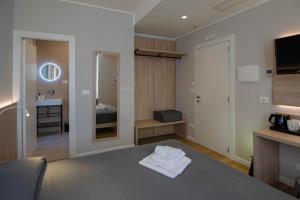 a hotel room with a bed and a bathroom at Hotel Tritone in Trieste