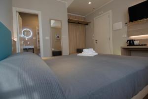 a bedroom with a large bed and a television at Hotel Tritone in Trieste