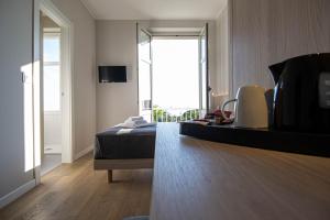 a bedroom with a bed and a large window at Hotel Tritone in Trieste