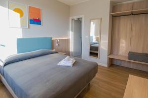 a bedroom with a large bed with towels on it at Hotel Tritone in Trieste