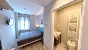 a small bedroom with a bed and a sink at Hotel Tritone in Trieste