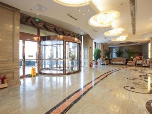 a lobby of a hotel with a large room with windows at Vienna Hotel Tianjin Guizhou Road Branch in Tianjin