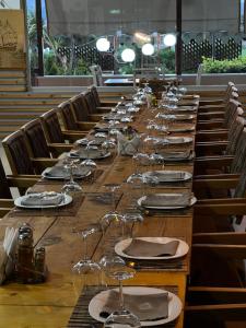 a long wooden table with wine glasses on it at Guesthouse Osumi in Berat