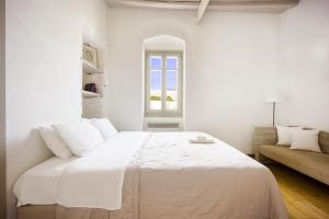 Un dormitorio blanco con una cama y un sofá. en Folegandros Chora Bliss by Estia, en Chora Folegandros