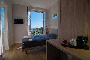 a hotel room with a bed and a balcony at Hotel Tritone in Trieste