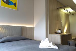 a bedroom with a bed with a white towel on it at Hotel Tritone in Trieste