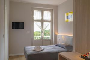 a bedroom with a bed and a large window at Hotel Tritone in Trieste