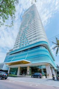 a tall building with cars parked in front of it at TMS Quy Nhơn-Chuee Homestay in Quy Nhon
