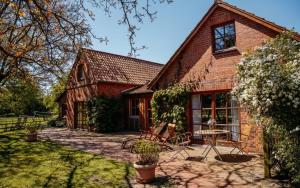 a brick house with a table and chairs in the yard at Ferienhof Trapp in Ellringen