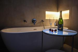 a bathroom with a bottle of wine and two wine glasses at Bohém Borklub in Tállya