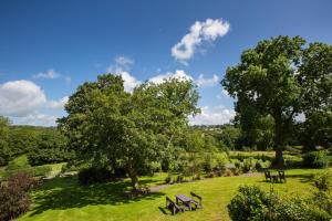 a park with benches and trees on a field at Penbontbren Luxury Bed and Breakfast in Aberporth