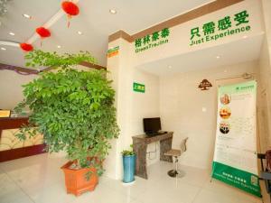 un magasin avec une grande plante verte et une enseigne dans l'établissement GreenTree Inn Suzhou Exhibition Center Express Hotel, à Suzhou