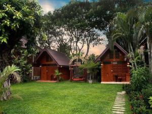 une maison avec une cour verdoyante devant elle dans l'établissement Rommai Reunngam Resort, à Ban Chang Kham Luang