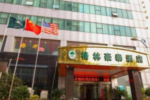 a building with three flags in front of it at GreenTree Inn JiangSu WuXi BinHu TaiHu Pearl Development Mansion Business Hotel in Wuxi