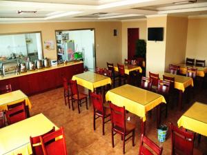 a restaurant with tables and chairs and a counter at GreenTree Inn MaAnshan Economic Development District Hongqi South Road Express Hotel in Ma'anshan +158 photos