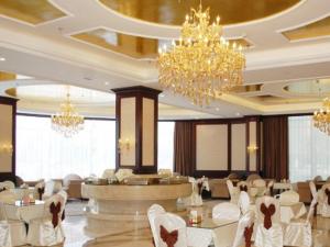 a hotel lobby with white chairs and chandeliers at Vienna Hotel Qingdao Jiaozhou Branch in Qingdao +14 photos