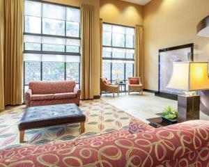 a living room with a bed and a living room with windows at Comfort Suites in Rome
