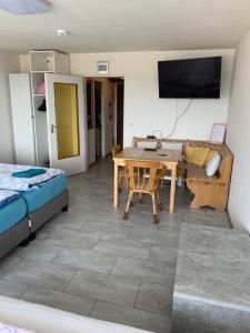a living room with a table and a tv at Studio, Bergblick, 2 Betten, 1 Schlafsofa in Bad Reichenhall